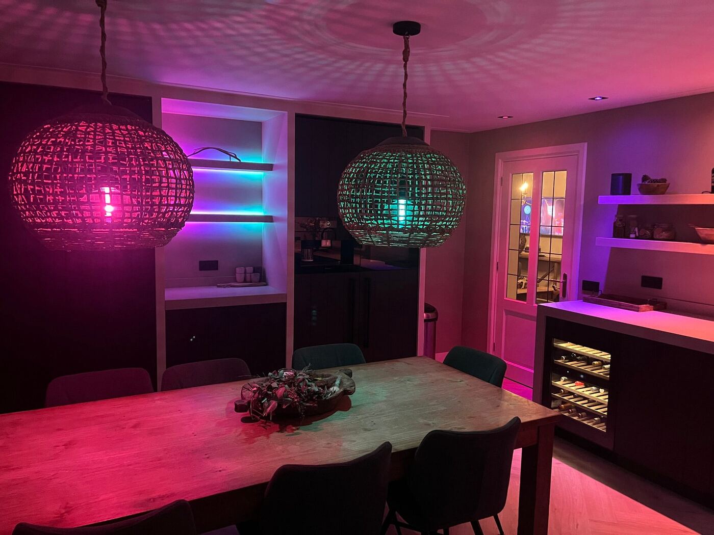 Eetkeuken met hanglampen in roze en groen licht